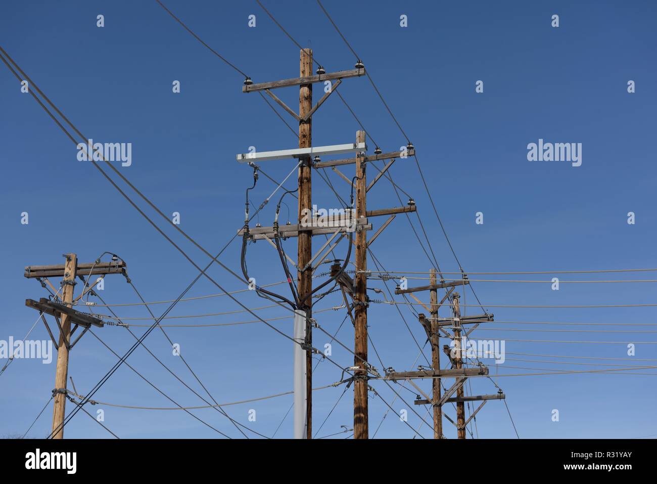Infrastructure de distribution de réseau électrique, rangée de poteaux de services publics et lignes électriques haute tension avec un ciel bleu dans le Dakota du Sud, États-Unis Banque D'Images