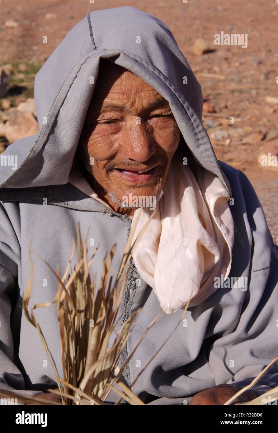 Marrakech, Maroc - 21,02,2012 : un ancien général de l'artisanat berbère habillée homme bracelets de paille dans les contreforts des montagnes du Haut Atlas. Banque D'Images