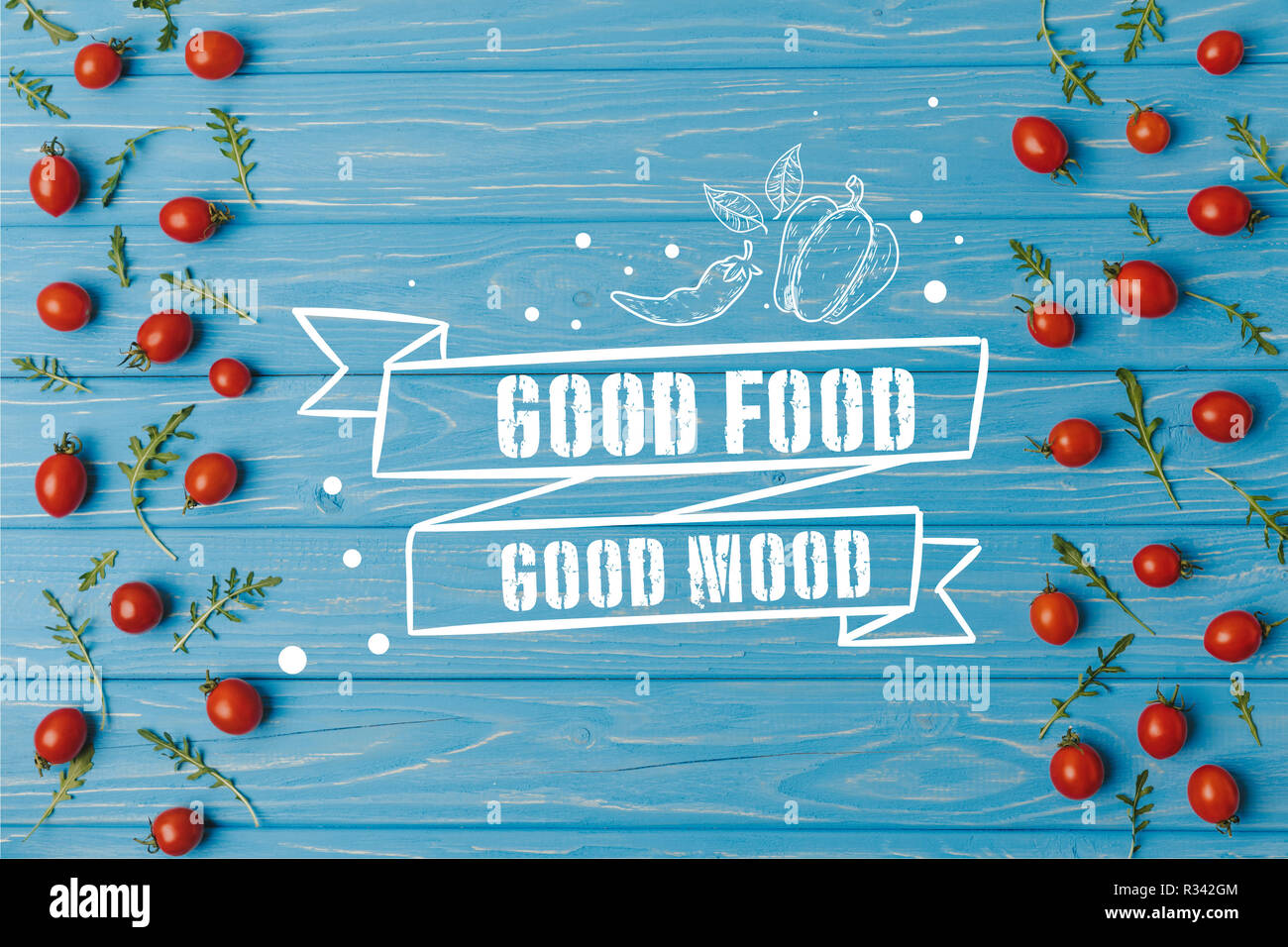 Vue de dessus les tomates cerise avec roquette sur table bleue, bonne nourriture bonne humeur le lettrage Banque D'Images