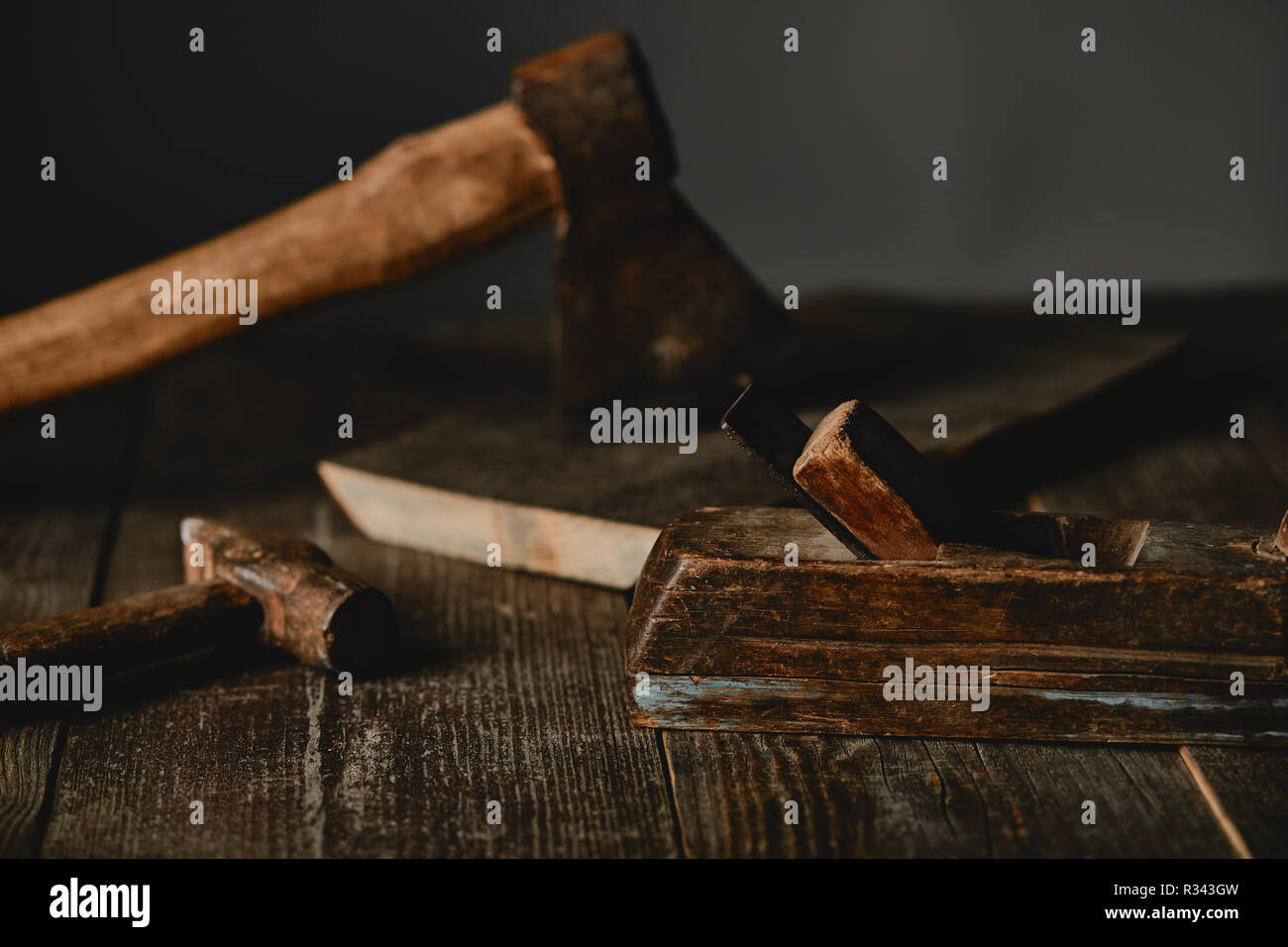 Vue rapprochée d'ax, de marteaux et de bois de sciage sur table en bois sur fond gris Banque D'Images