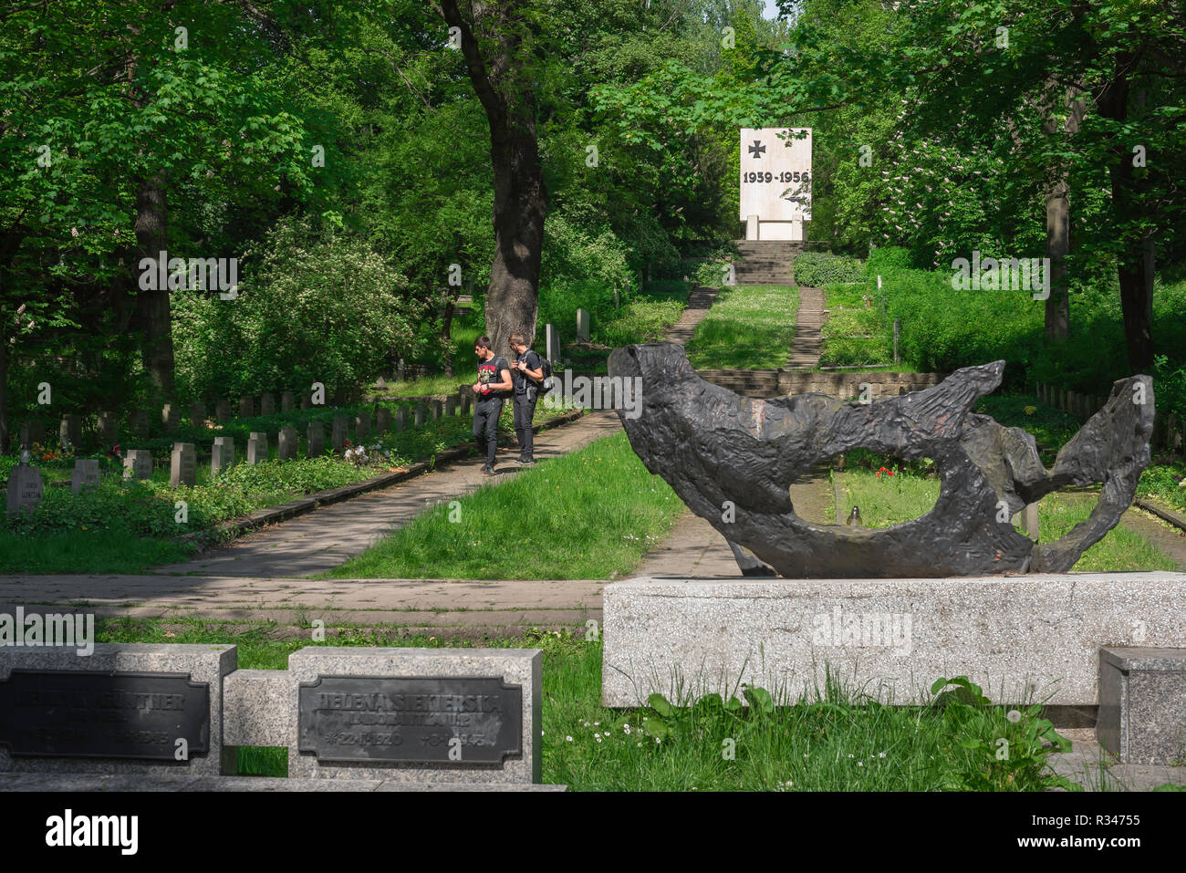 Cimetière de Poznan, vue de deux jeunes hommes dans le parc de la Citadelle de Poznan à cimetière sur les tombes de soldats polonais tués lors de la DEUXIÈME GUERRE MONDIALE, Poznan, Pologne. Banque D'Images