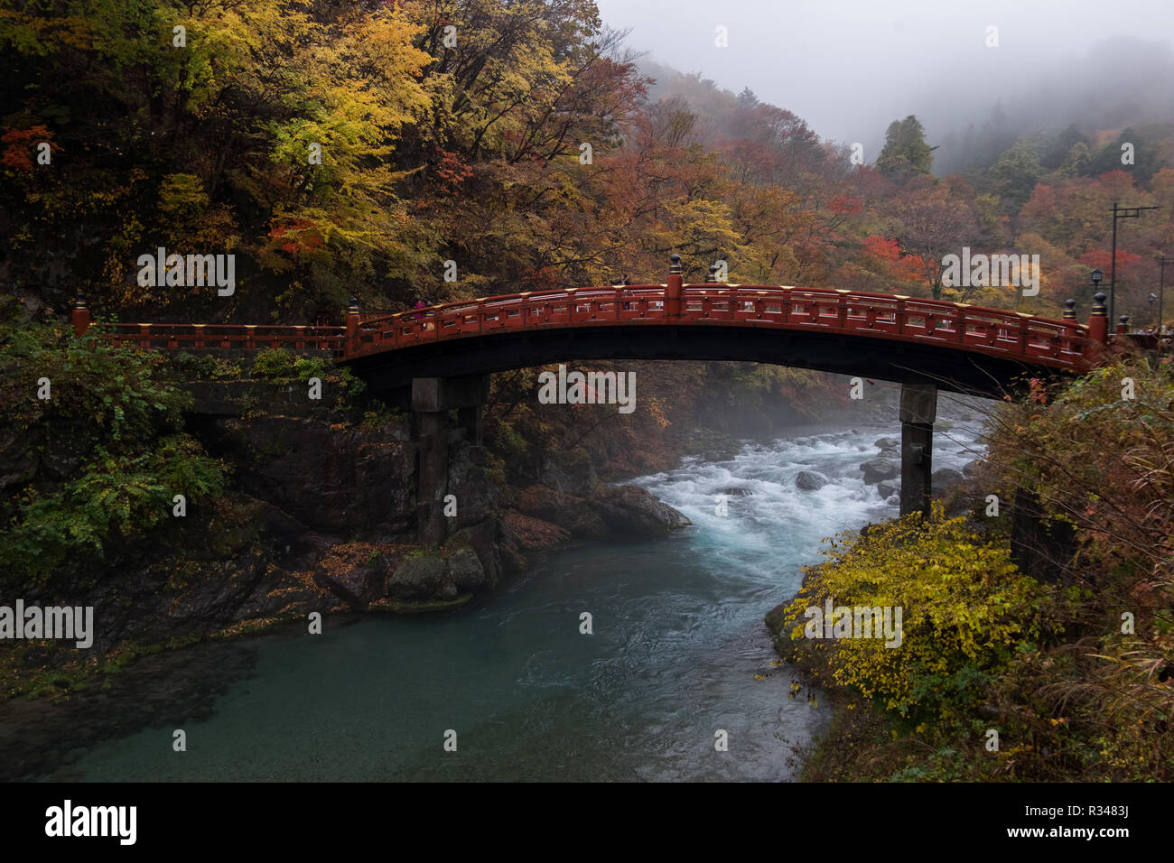 Regardant le magnifique pont Shinkyo à Nikko, Japon sur une journée d'automne brumeux, avec des pics de la couleur de l'automne. Banque D'Images