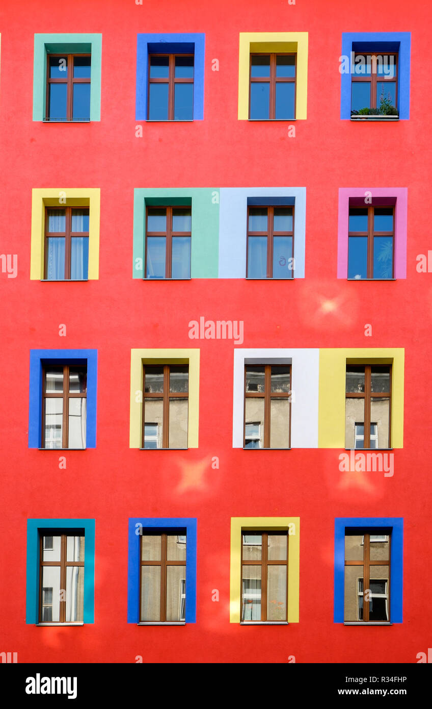 Une façade de maison rouge avec des fenêtres colorées Banque D'Images