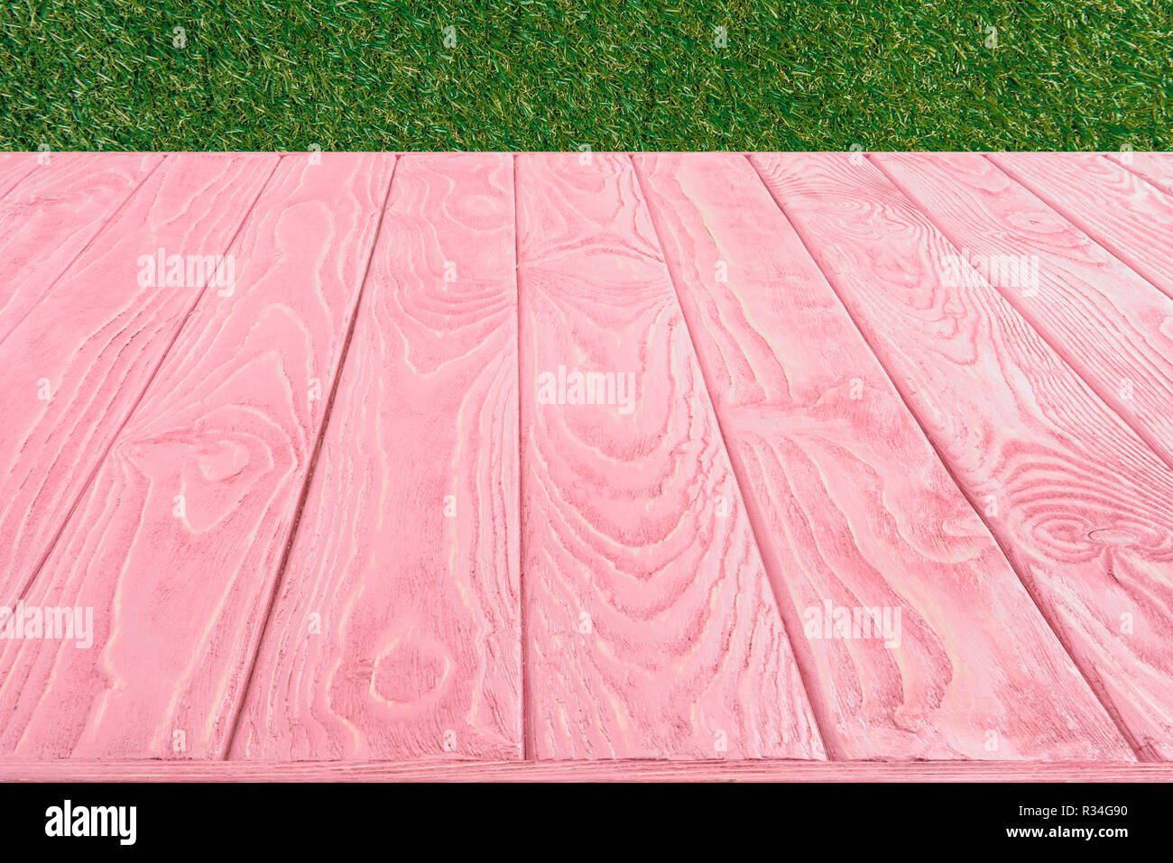 Surface des planches en bois de rose sur fond d'herbe verte Banque D'Images