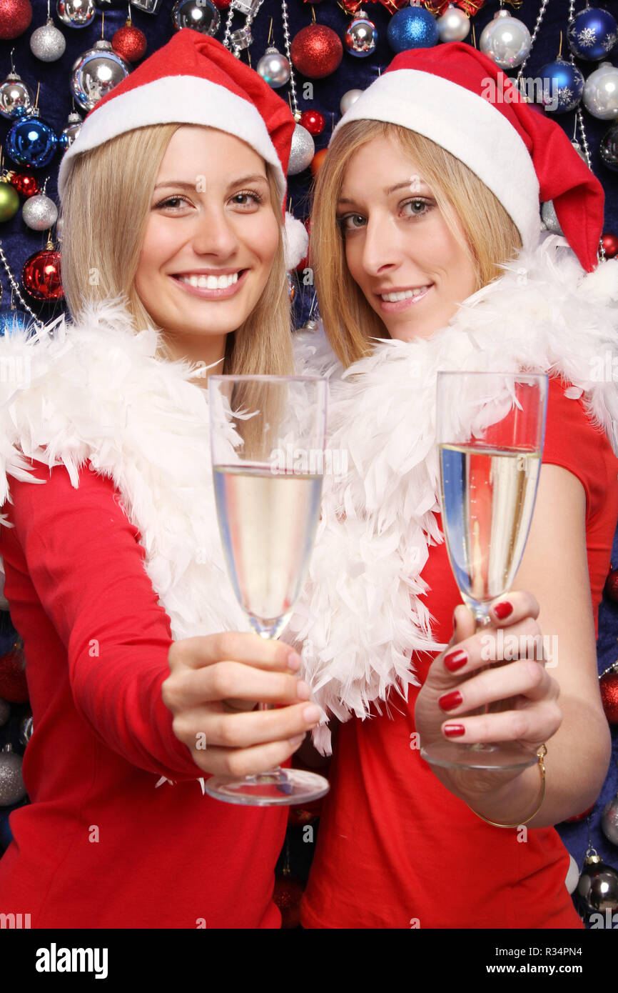 2 femmes en costumes de Noël et verre de vin mousseux Banque D'Images