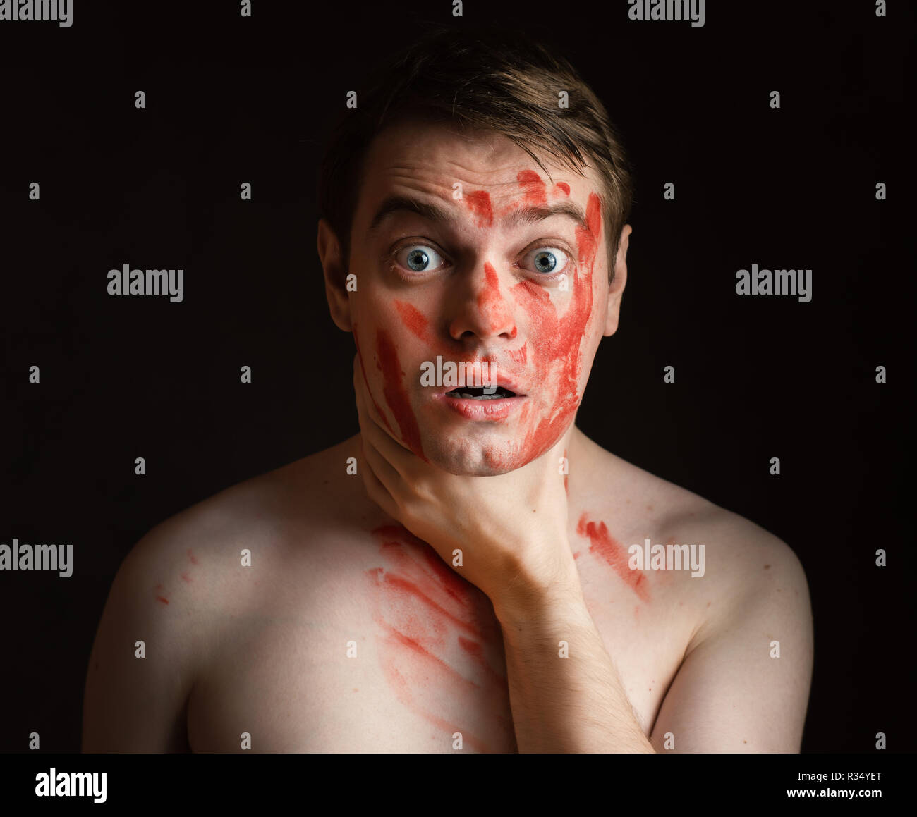 Jeune homme avec du sang sur son visage pour se tenir le cou. Banque D'Images