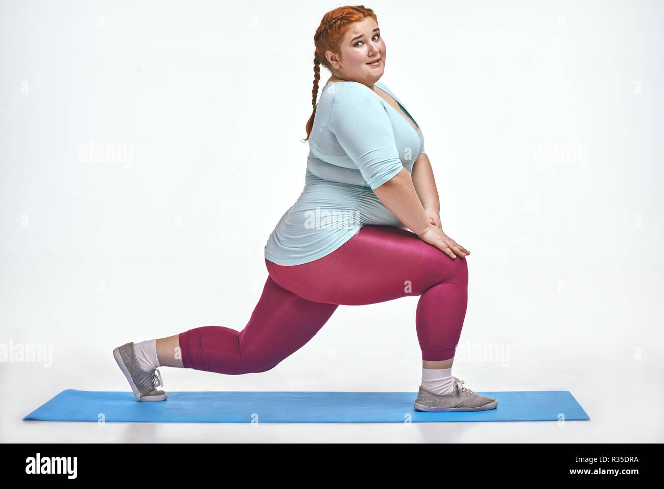 Amusant, red haired chubby, femme de trains sur le tapis Banque D'Images