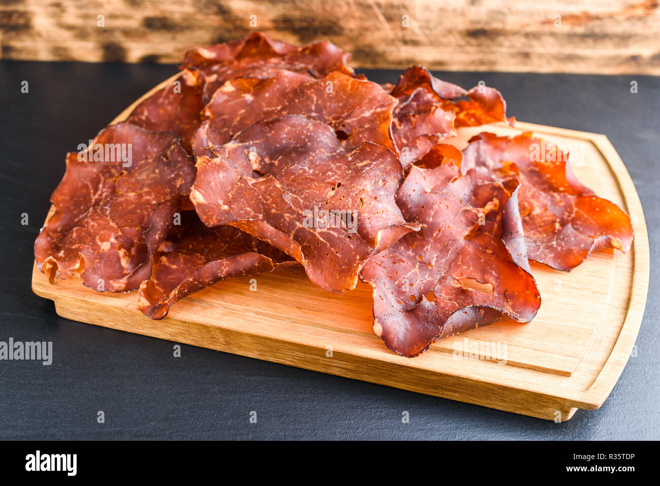 Émincé de jambon fumé et séché sur bac de chêne de petits cristaux de sel visible sur la viande. Banque D'Images