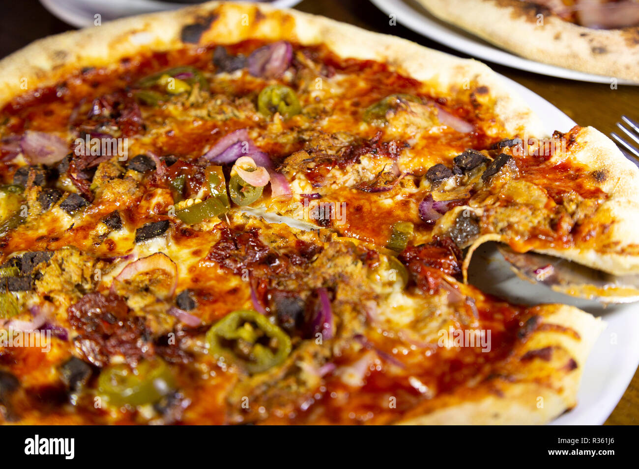 Pizza au levain servie sur une assiette dans un restaurant de pizza. Banque D'Images