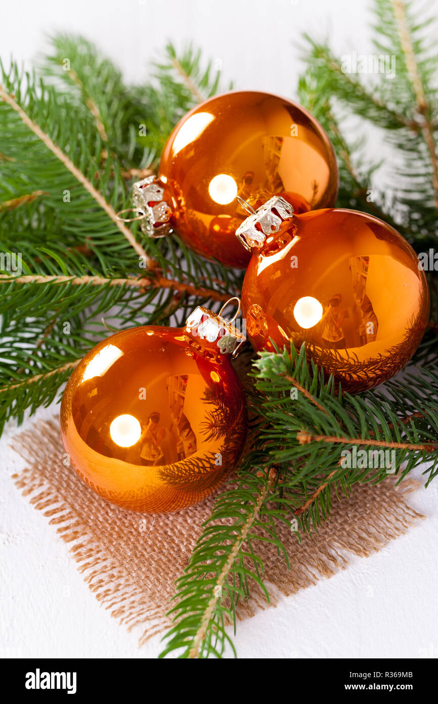 Boules de verre orange brillant des boules de Noël avec des branches vertes  sur un sac de jute Photo Stock - Alamy