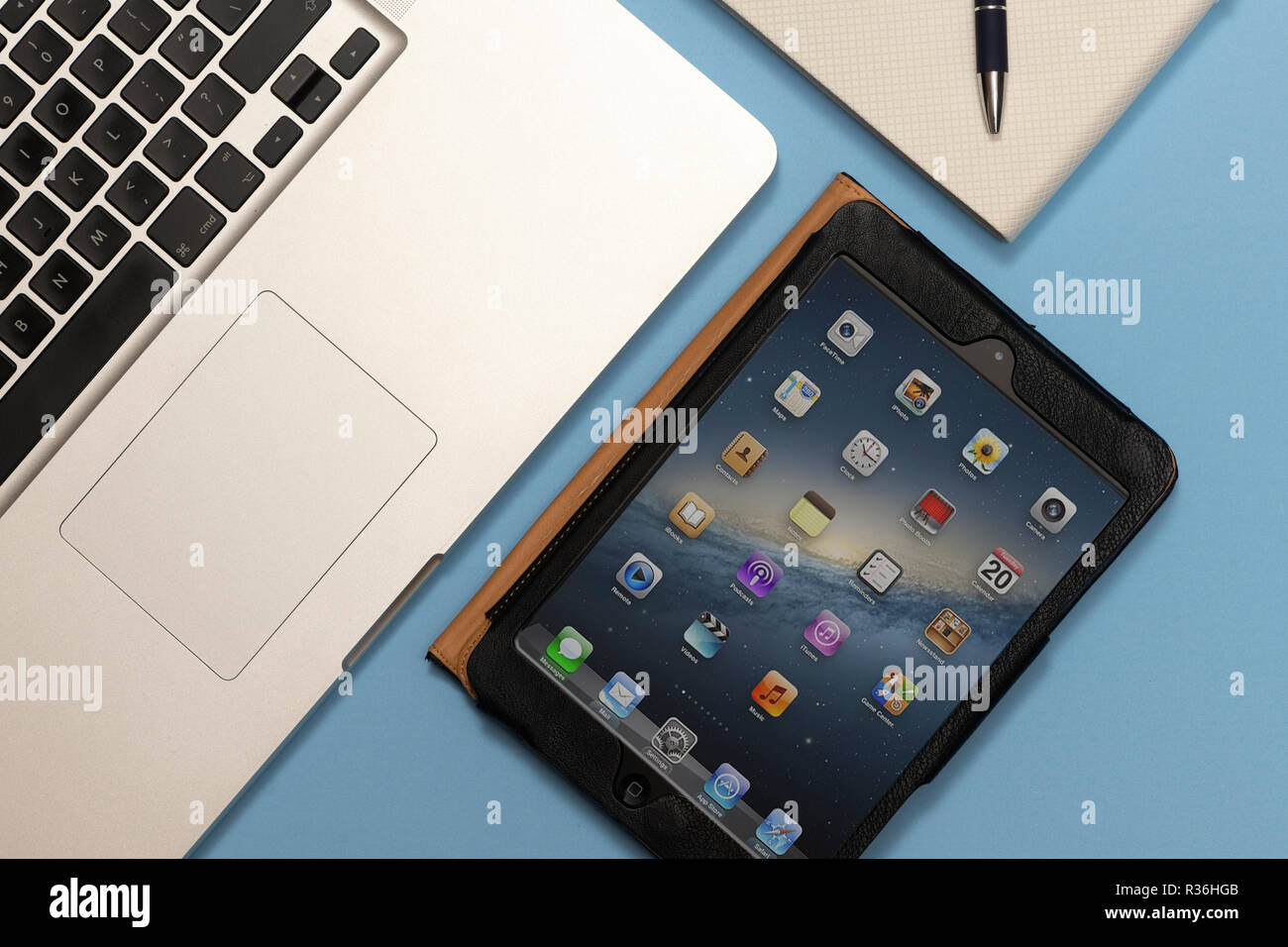 Ordinateur portable, iPad mini et un carnet de notes sur un bureau, télévision. Banque D'Images