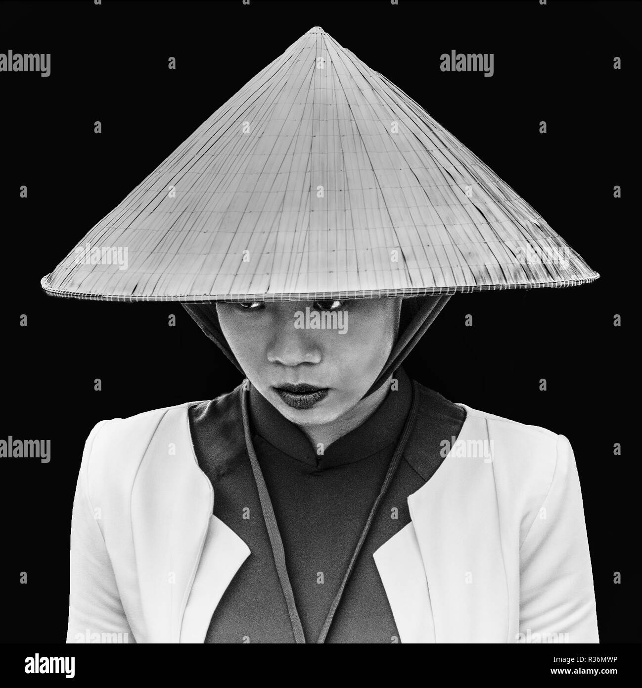 Le noir et blanc portrait de jeune dame vietnamienne en Chapeau conique traditionnel. Banque D'Images