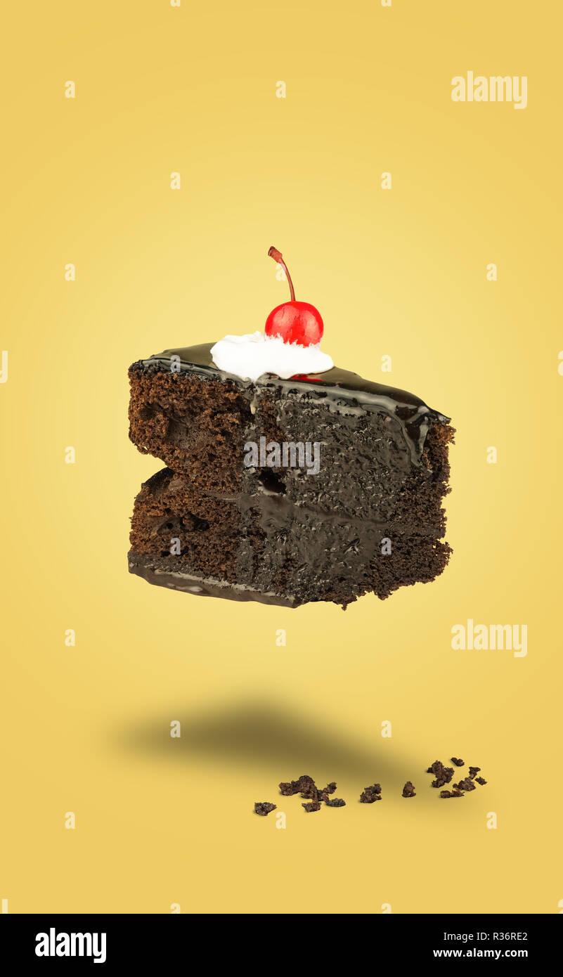 Gâteau cerise chocolat isolé battant sur fond jaune. Tarte au chocolat. Brownie de vol avec de la crème. Banque D'Images