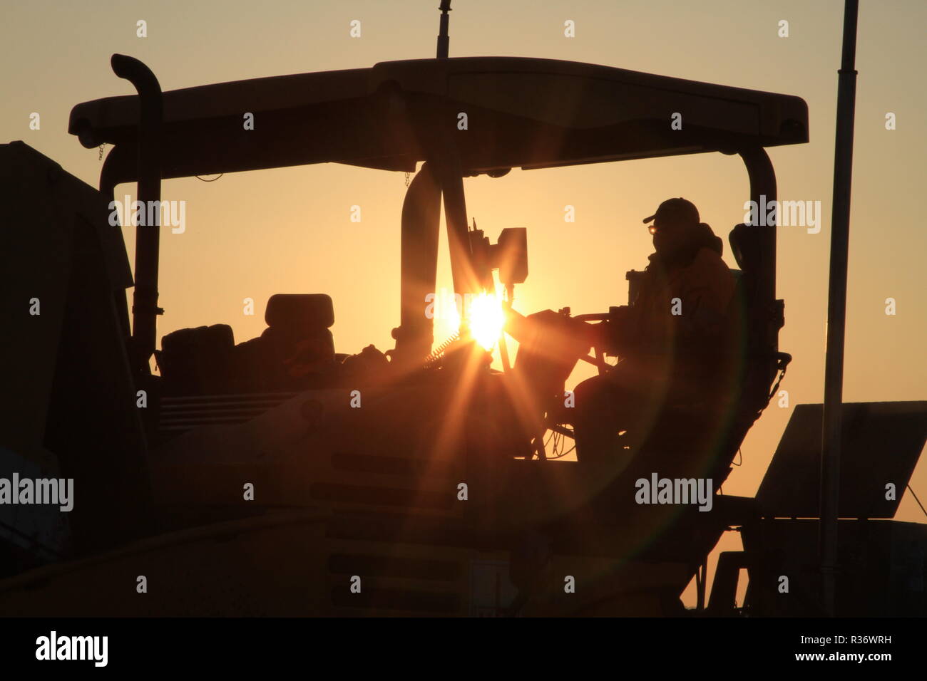 Un coup d'un travailleur qui contrôle une machine d'asphalte pour pavage Banque D'Images