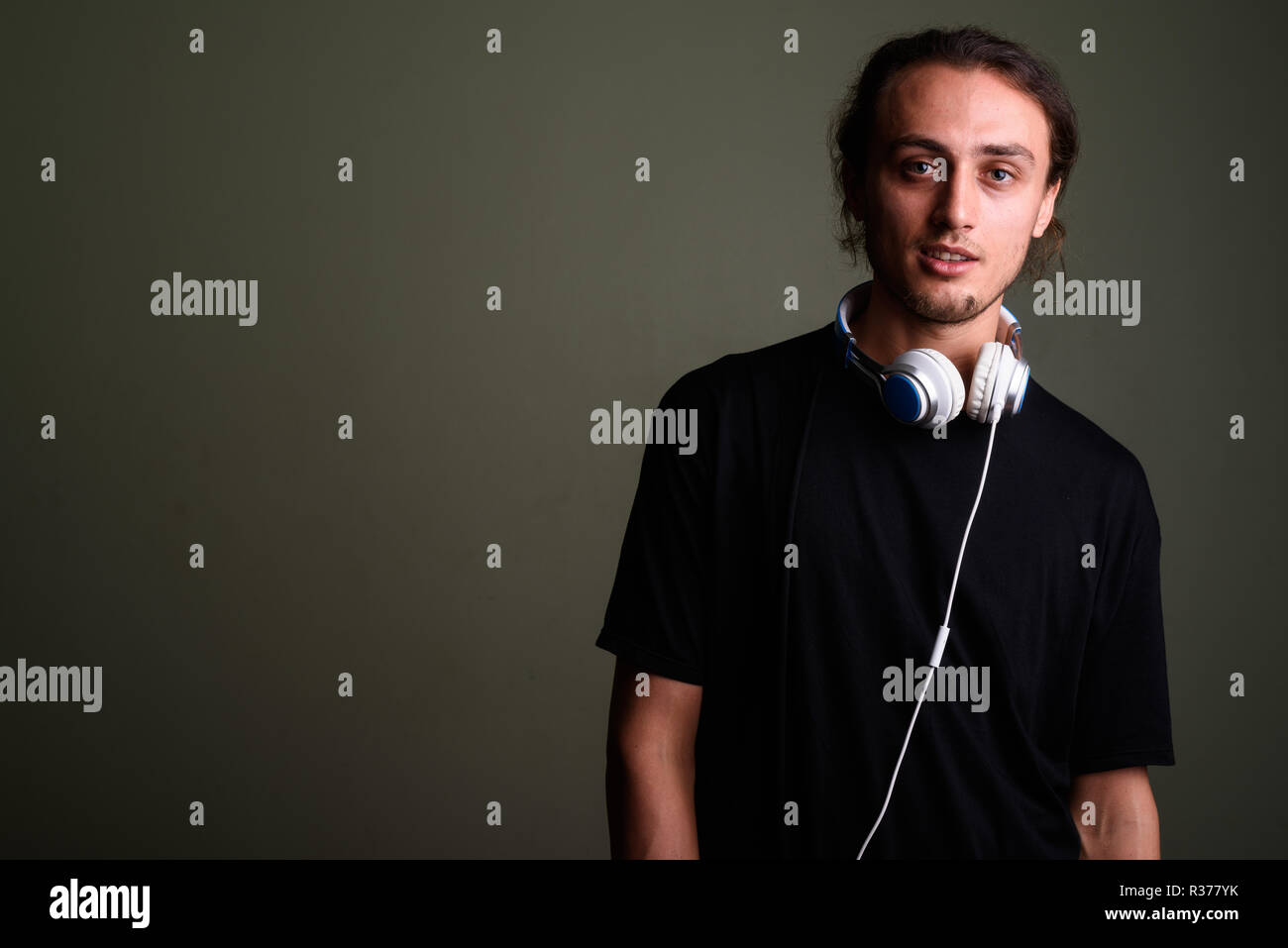 Beau jeune homme portant des écouteurs à l'arrière-plan coloré Banque D'Images