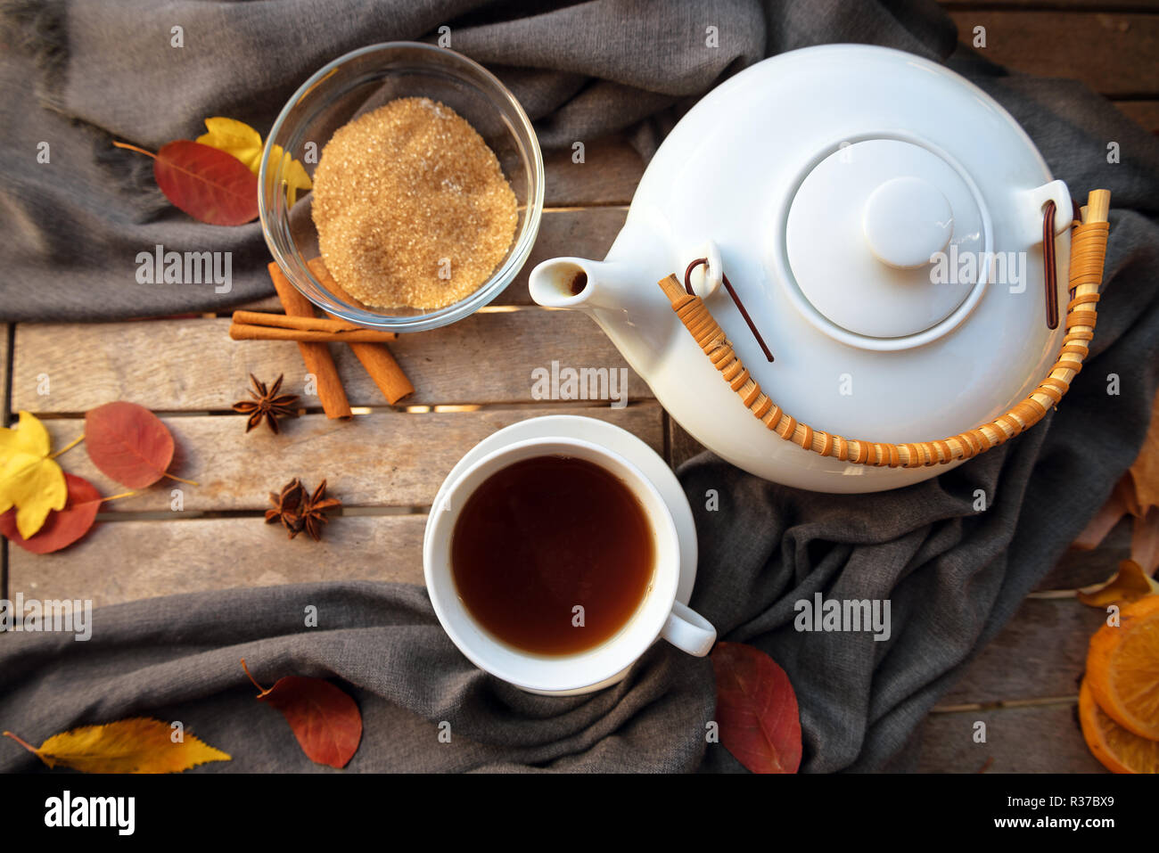 Tasse de thé et une théière blanche sur une table en bois avec des épices et des feuilles de l'automne, high angle vue de dessus, l'accent sélectionné Banque D'Images