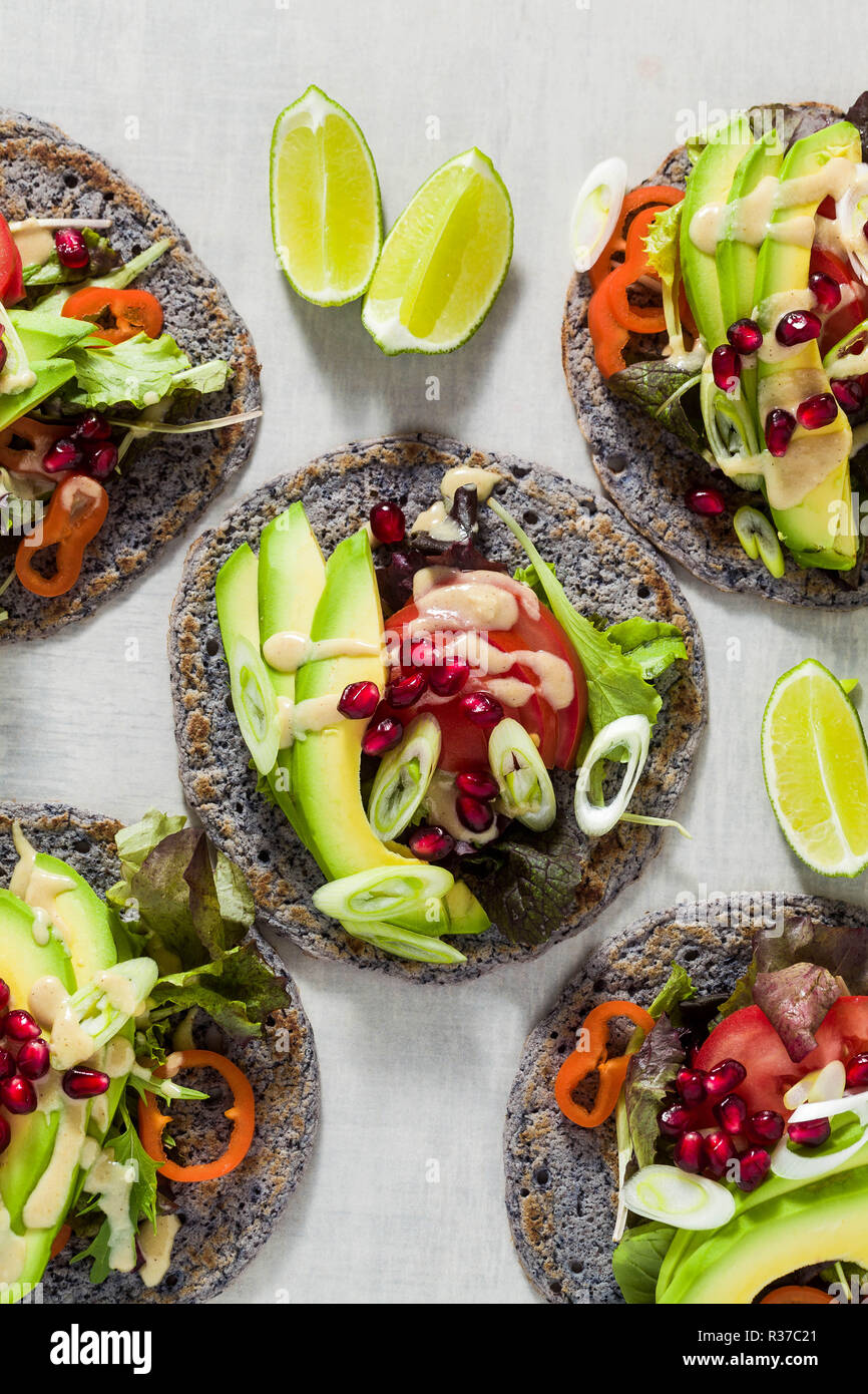 Tacos vegan sans gluten de haricot noir avec de la tomate et d'avocat salade avec sauce tahini et graines de grenade. saine restauration rapide pour l'ensemble de la famil Banque D'Images
