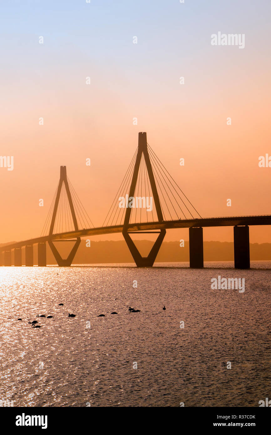 Pont de Faro au coucher du soleil la lumière, le pont routier sur l'Storstroem au Danemark relie les îles et fait partie de la vogelfluglinie (vol l'oiseau Banque D'Images