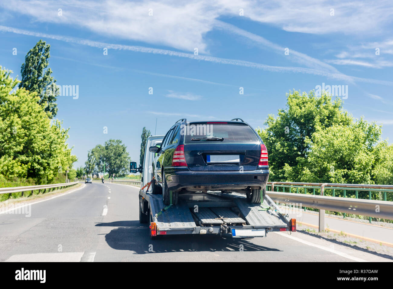 Remorque porte-voiture avec voiture. Location transportés sur un camion de remorquage d'évacuation sur l'autoroute Banque D'Images