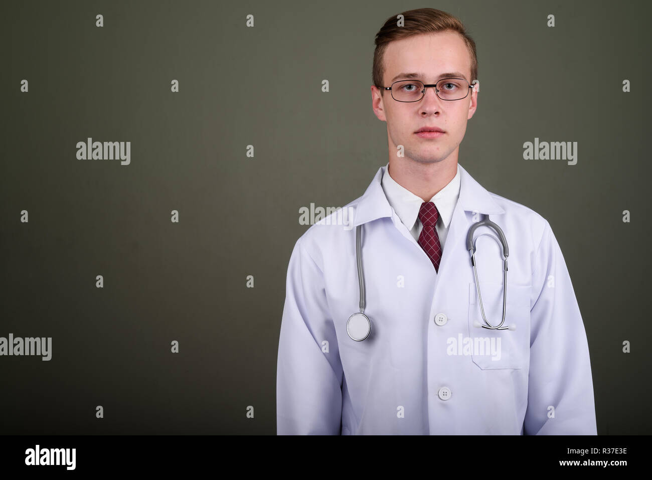 Jeune homme séduisant médecin contre l'arrière-plan de couleur Banque D'Images