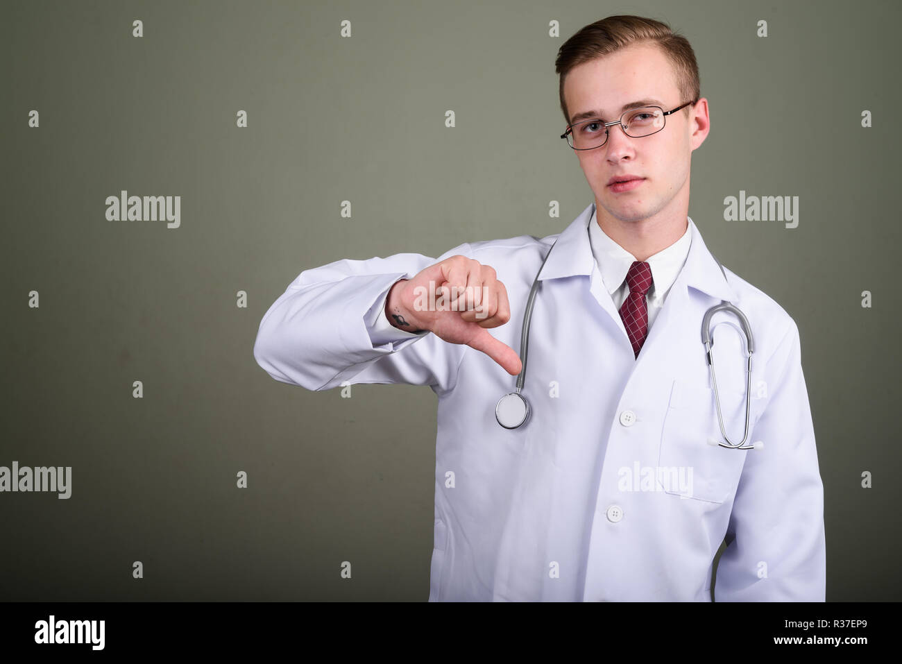 Jeune homme séduisant médecin contre l'arrière-plan de couleur Banque D'Images