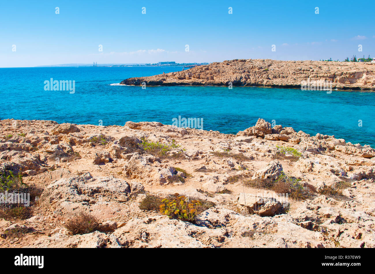 Image d'une baie près de plage Vathia Gonia, Agia Napa, Chypre. Littoral calcaire rugueux près de l'eau d'un bleu profond et rocky hill sur l'arrière-plan. Journée chaude je Banque D'Images