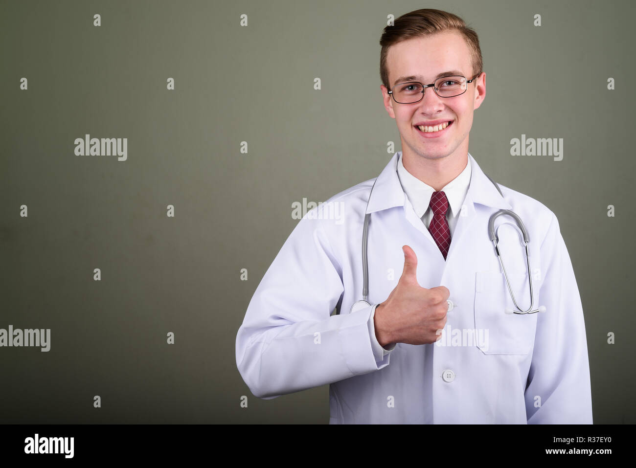 Jeune homme séduisant médecin contre l'arrière-plan de couleur Banque D'Images