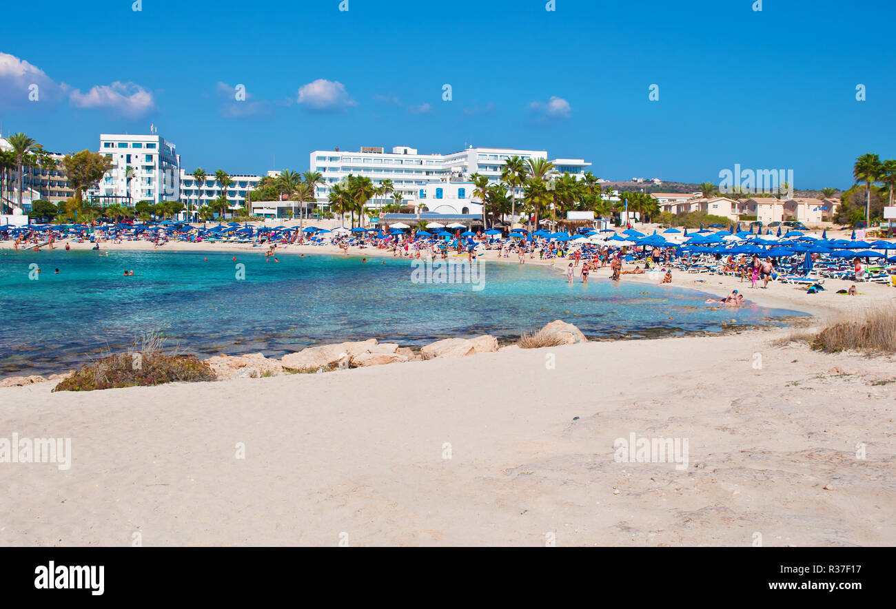 Image de Vathia Gonia beach près de Agia Napa, Chypre. Sable blanc et mer bleu turquoise avec de l'eau dans une baie et maisons en arrière-plan. Chaude journée de fa Banque D'Images