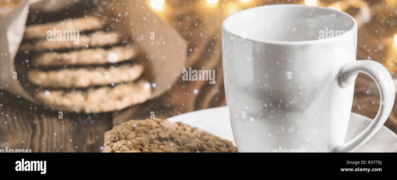 Tasse à thé sur une plaque à biscuits faits maison, cuisson sur table rustique en bois, servi avec des accessoires d'hiver. Maison de vacances hiver noël vie encore o Banque D'Images