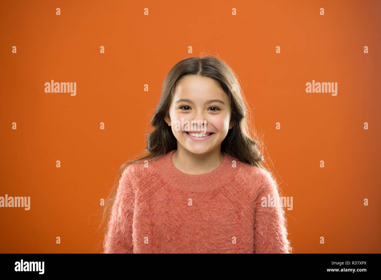 Quelle est la différence entre les faux et sincère sourire. Ce que la science a à dire sur de véritables et de faux sourires. Longs cheveux enfant happy smiling. Enfance heureuse concept. Cute Girl enfant heureux visage souriant. Banque D'Images