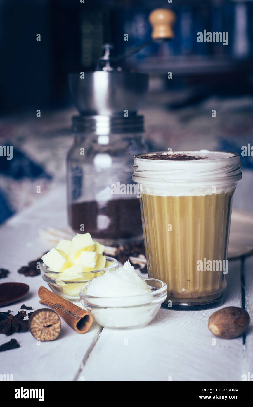 Café à toute épreuve. Régime cétogène café avec l'huile de coco et de beurre (ghee). Tasse de café à toute épreuve et d'ingrédients, paléo régime alimentaire. Sur b en bois blanc Banque D'Images