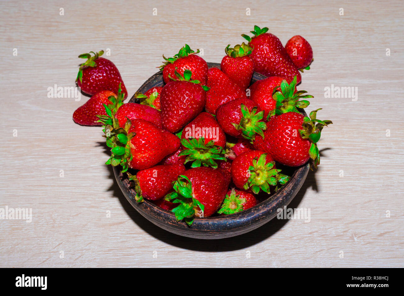 Fresas rojas y maduras frescas sobre vasija de greda Banque D'Images