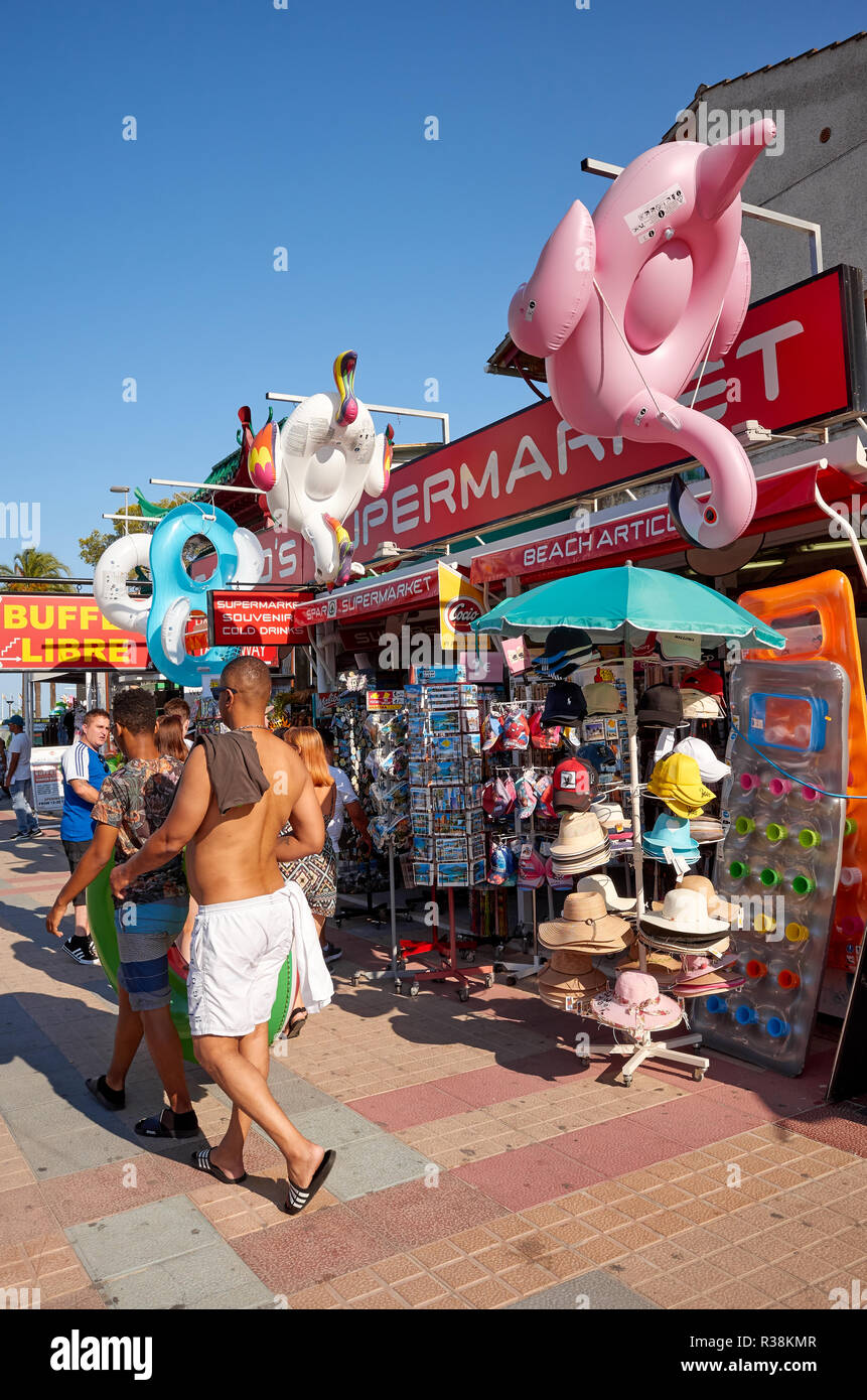 Port de Alcudia, Mallorca, Espagne - 20 août 2018 : boutiques de souvenirs par une rue dans le sud touristique de la ville au coucher du soleil. Banque D'Images
