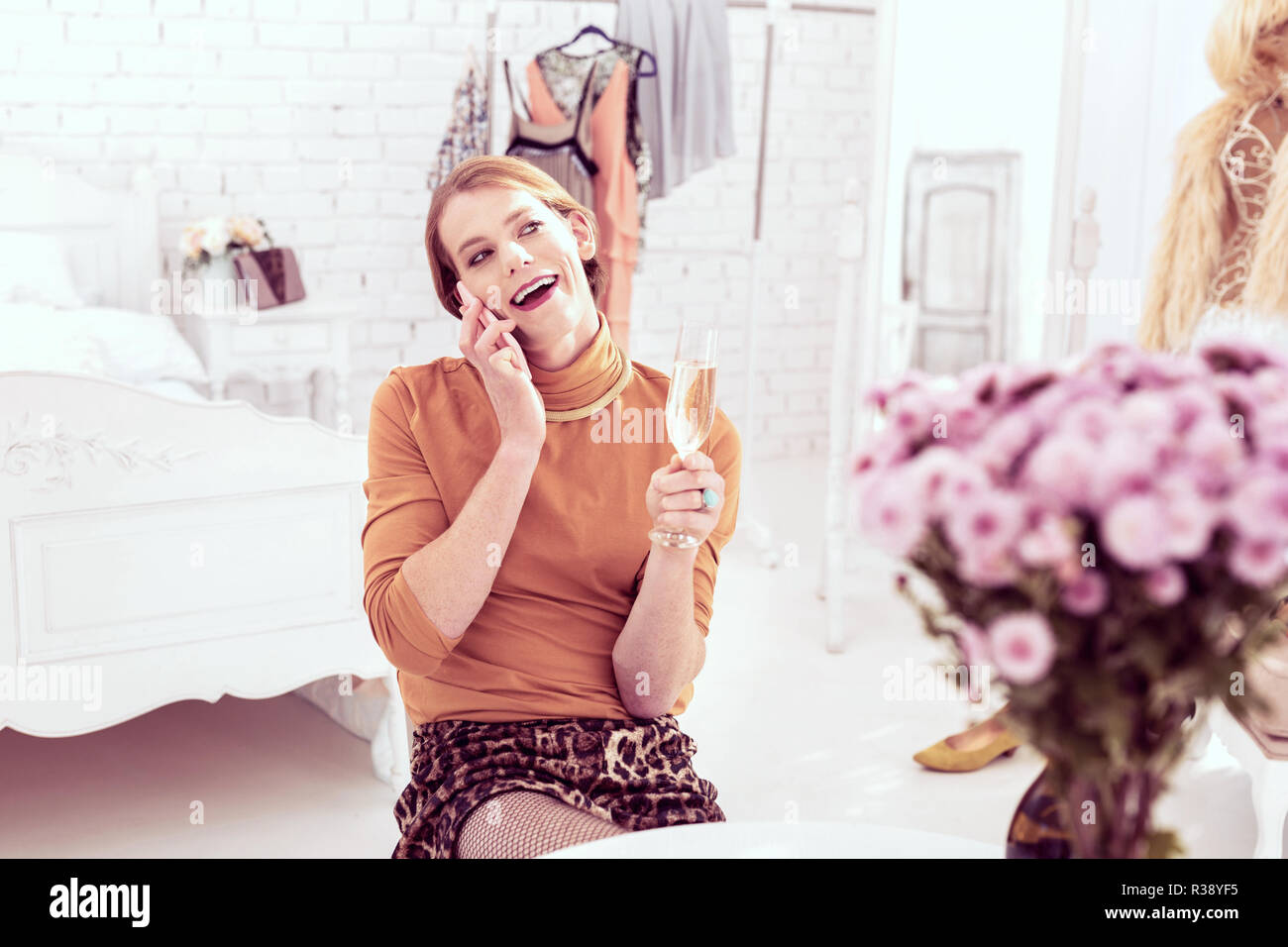 Sourire joyeux cross-habillé homme portant rempli wineglass Banque D'Images