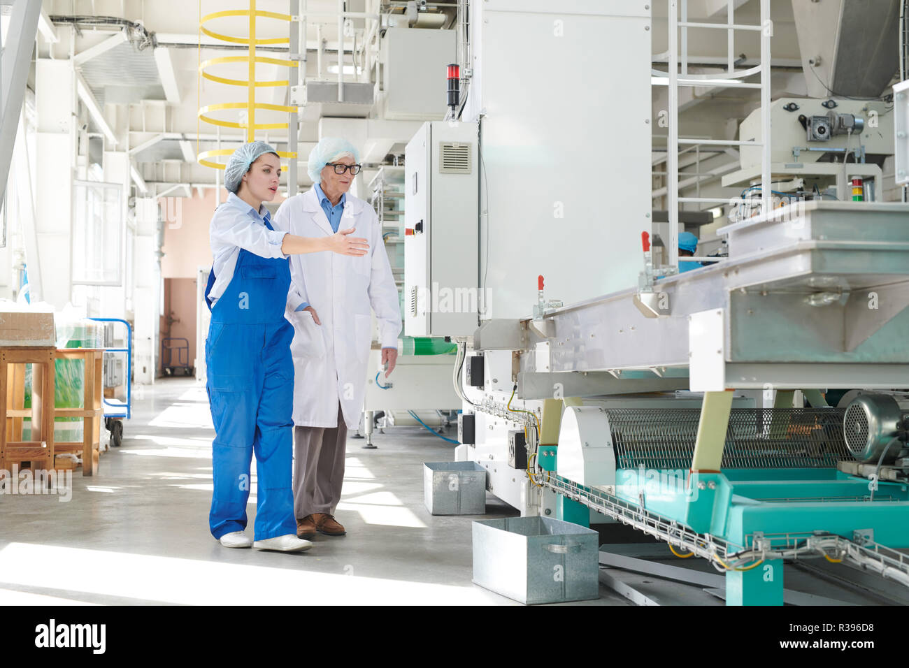 Jeune femme présentant l'équipement de l'usine Banque D'Images