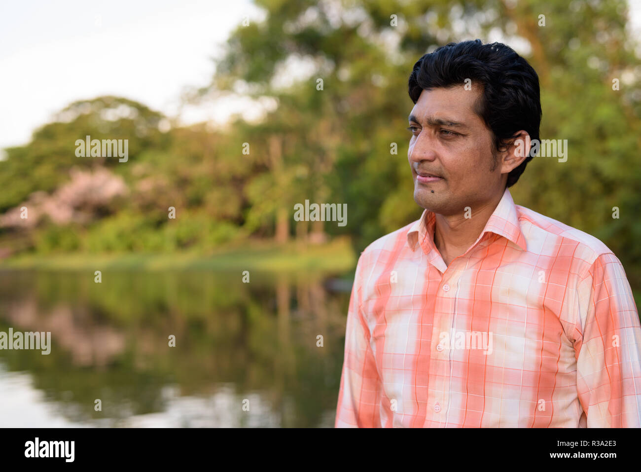 Close up of Indian man thinking contre vue pittoresque sur le lac Banque D'Images