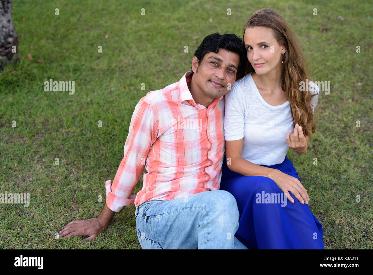 Multi Ethnic couple sitting on the prairie dans l'amour avec l'homme leani Banque D'Images