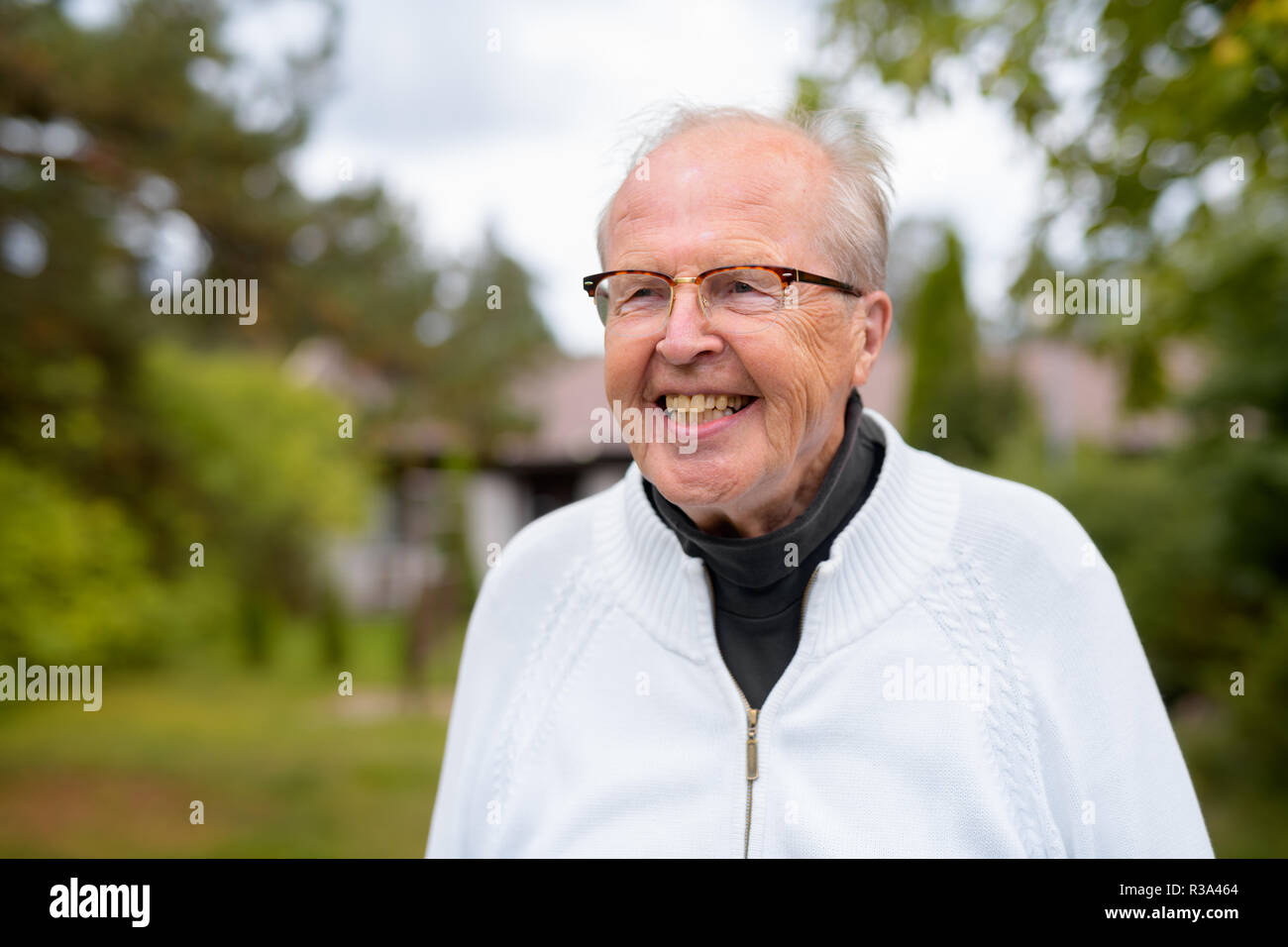 Happy Senior Man with Eyeglasses Smiling et de penser à la maison en plein air Banque D'Images