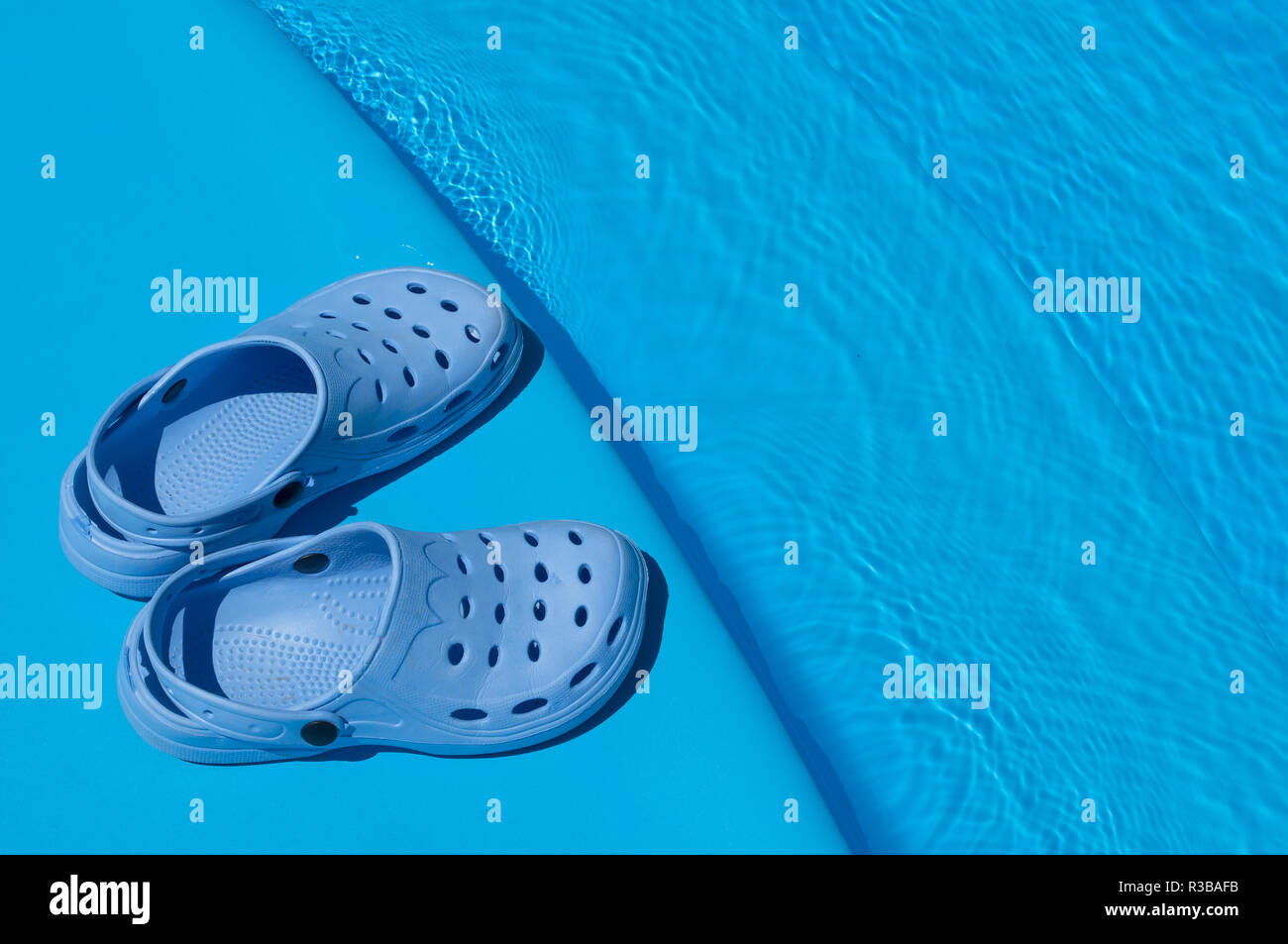 Une paire de chaussons bleu près de la piscine Banque D'Images