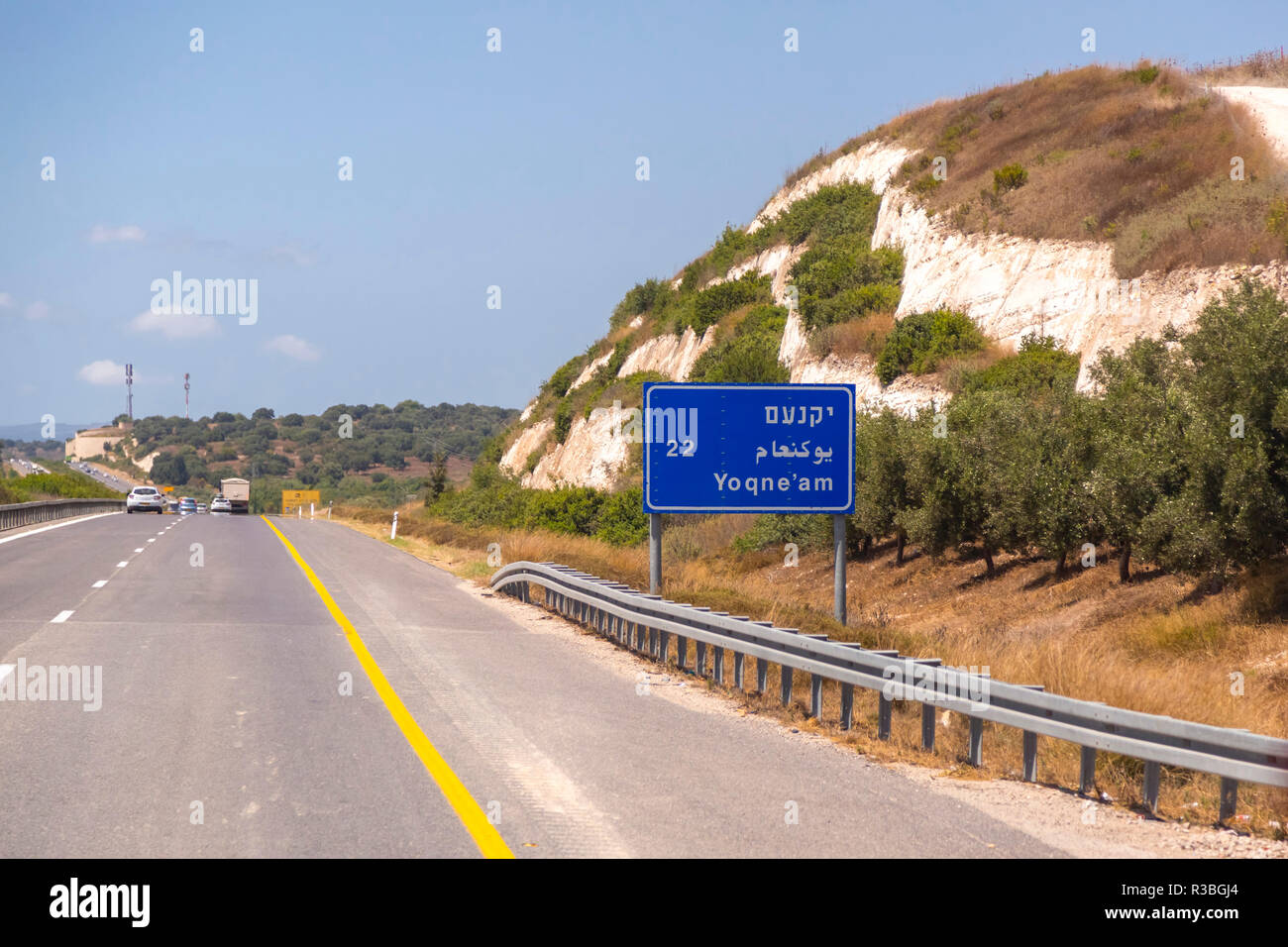 L'autoroute avec des signes et des véhicules en circulation de Jérusalem à Haifa sur une journée ensoleillée. Signe de Yoqne'am. Banque D'Images