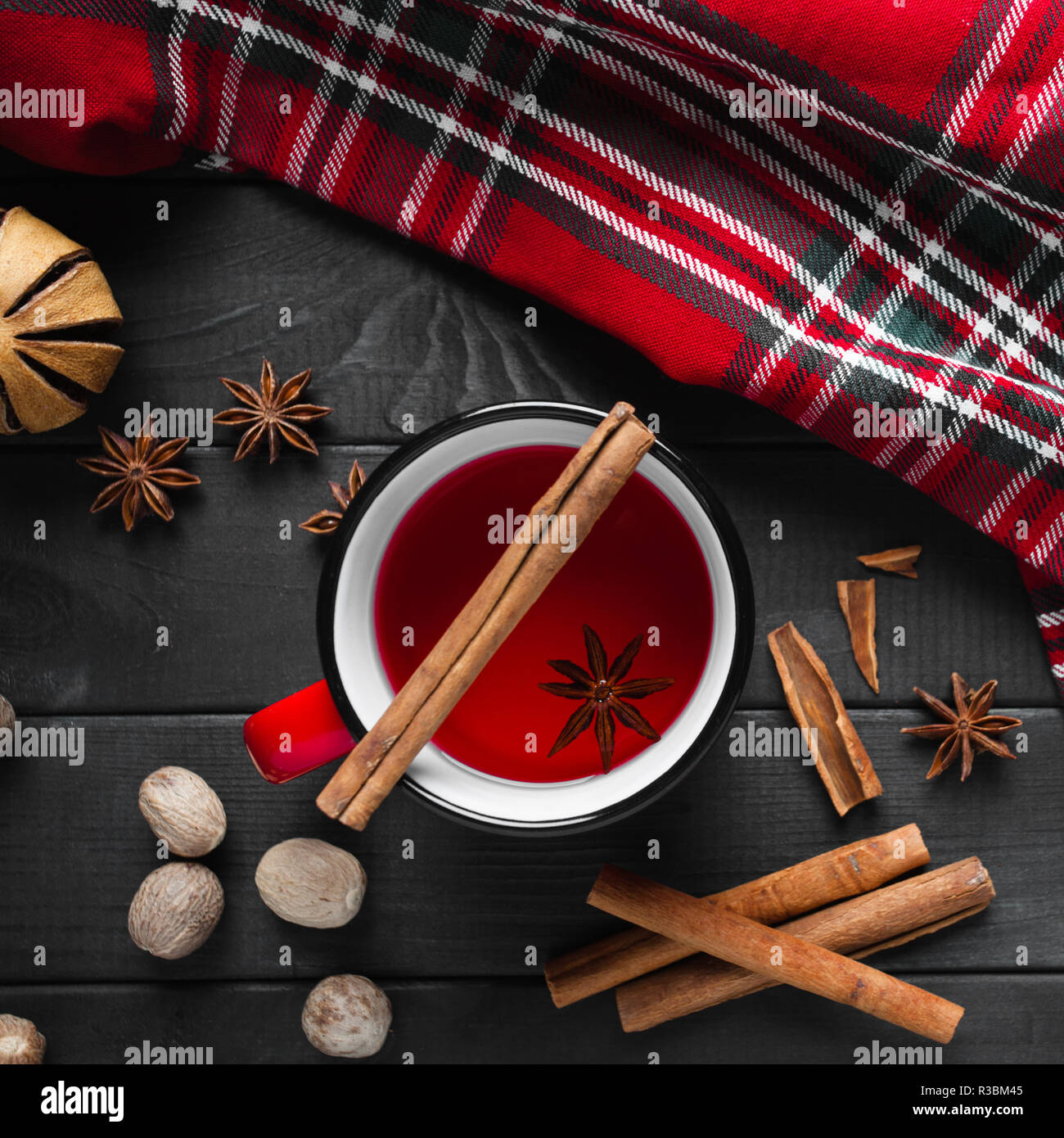 Vin chaud de Noël aux épices dans la tasse rouge sur fond en bois sombre. Banque D'Images