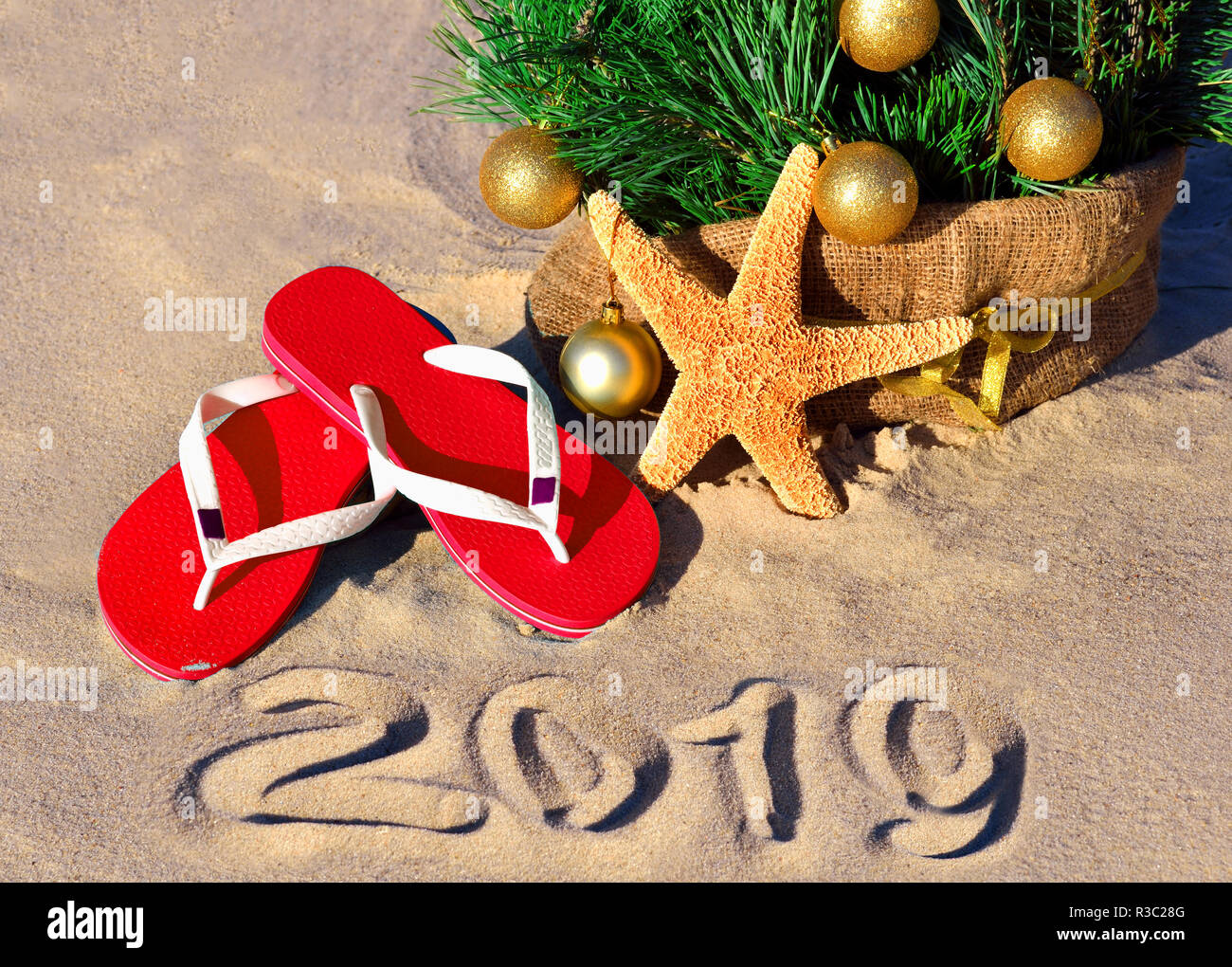 Nouvelle année 2019 sur la plage. Arbre de Noël, des étoiles et des chaussons dans le sable Banque D'Images