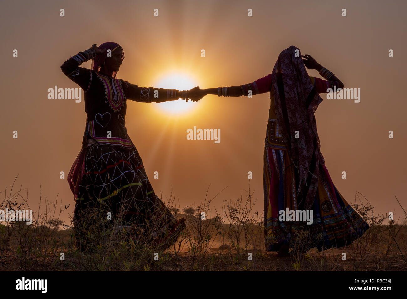 Deux silhouettes de femmes gitanes danser une danse traditionnelle au coucher du soleil, Pushkar Camel Fair, Pushkar, Rajasthan, India Banque D'Images