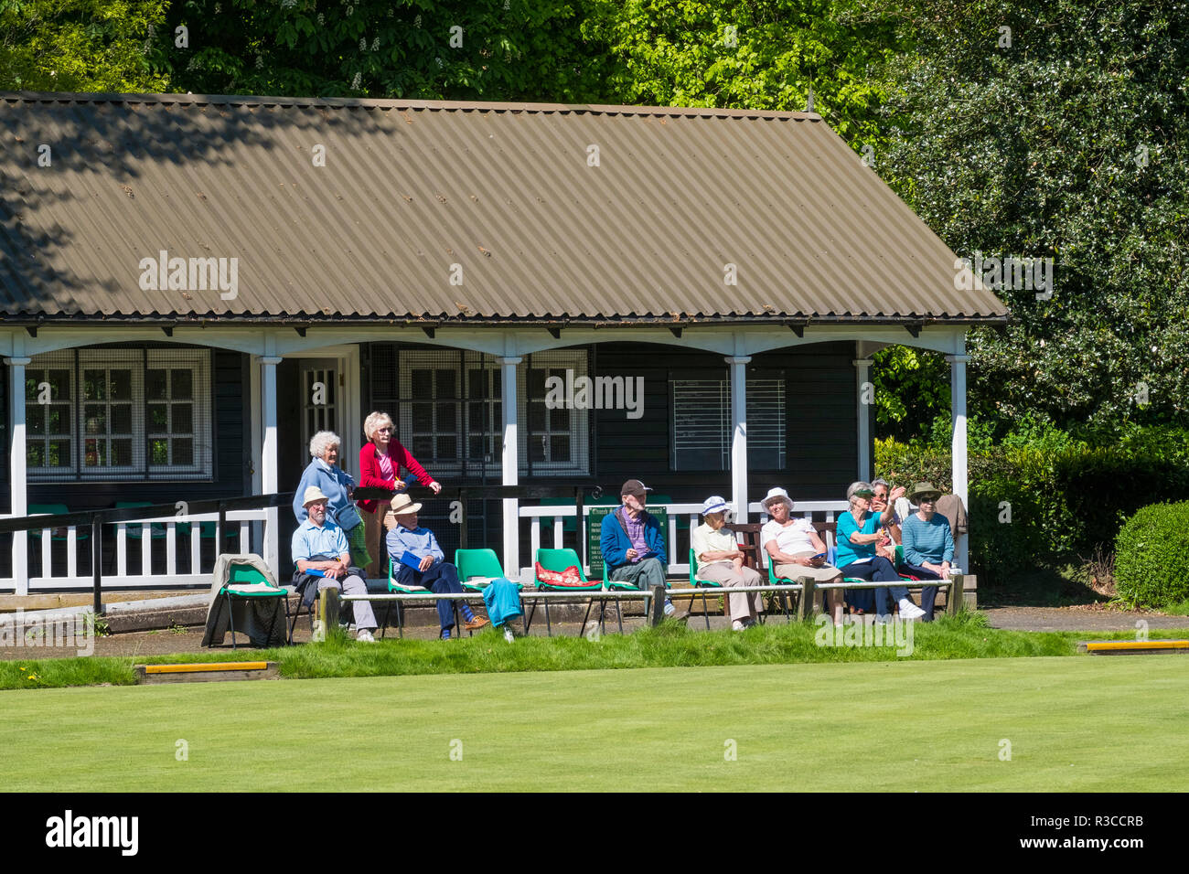 Membres de Church Stretton Bowling Club assis à l'extérieur le pavillon de regarder un match, Shropshire, England, UK Banque D'Images
