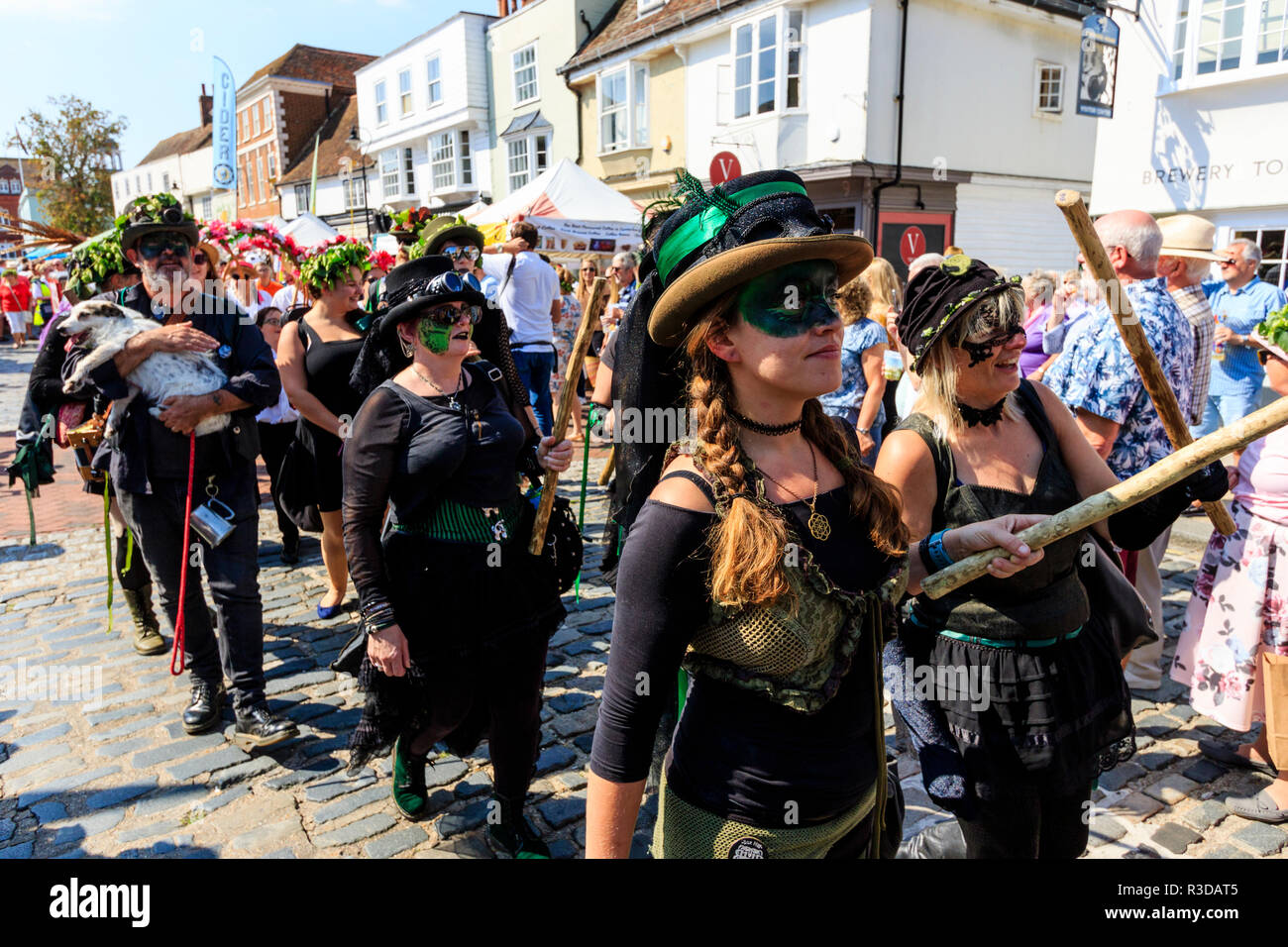 Faversham Hop Festival. Boxhill Bedlam Morris Dancers pass marche viewer en marchant dans le défilé. Les visages sont noirs peints sur sur les yeux. Banque D'Images