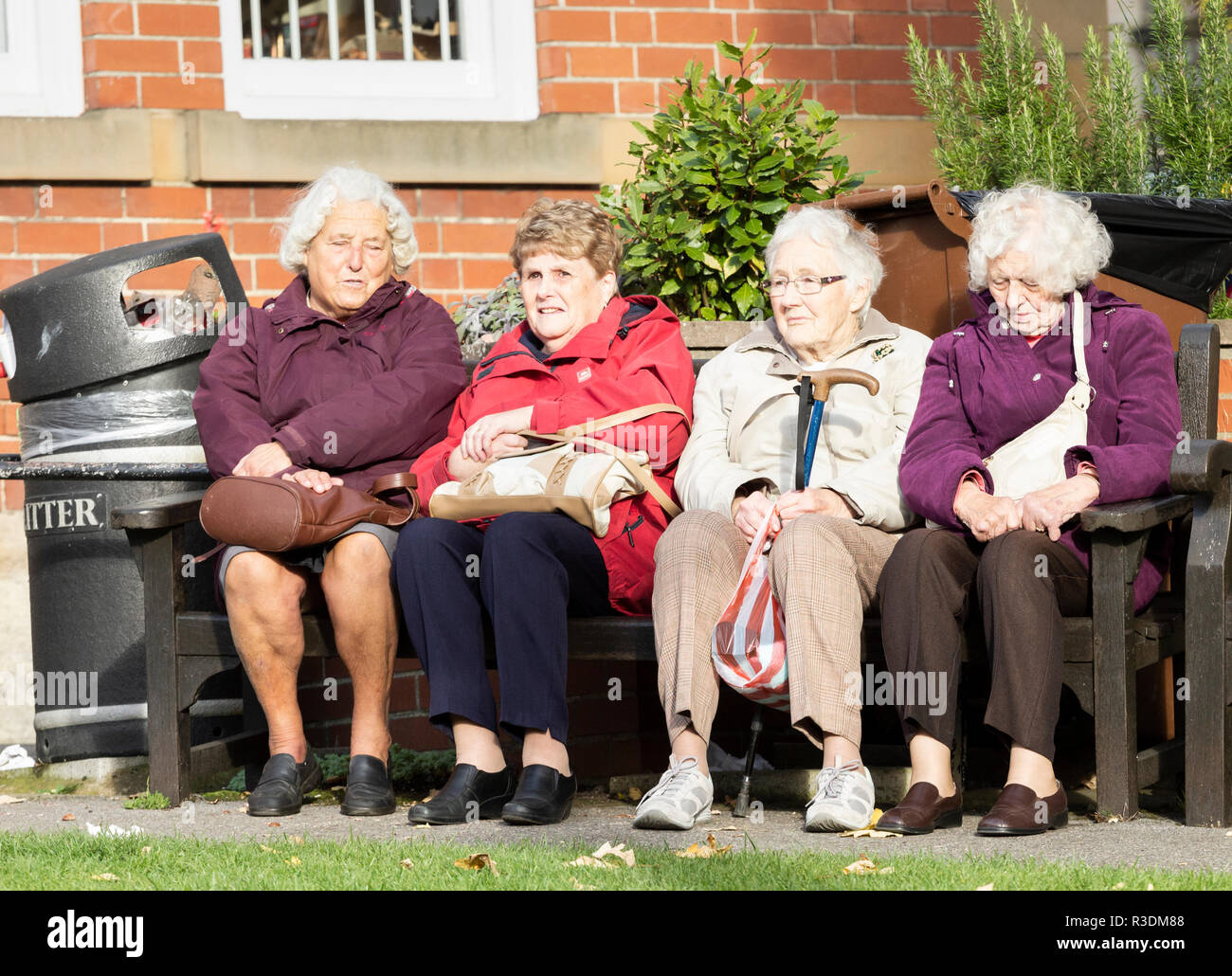 Quatre femmes âgées assis sur un banc. UK Banque D'Images