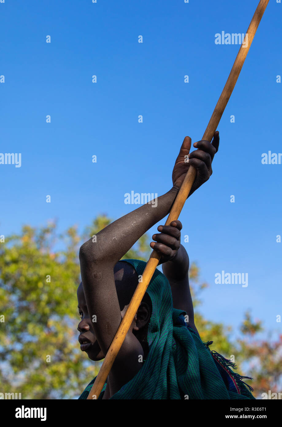 Suri tribu garçon avec un bâton au cours d'un rituel donga, vallée de l'Omo, Kibish, Ethiopie Banque D'Images