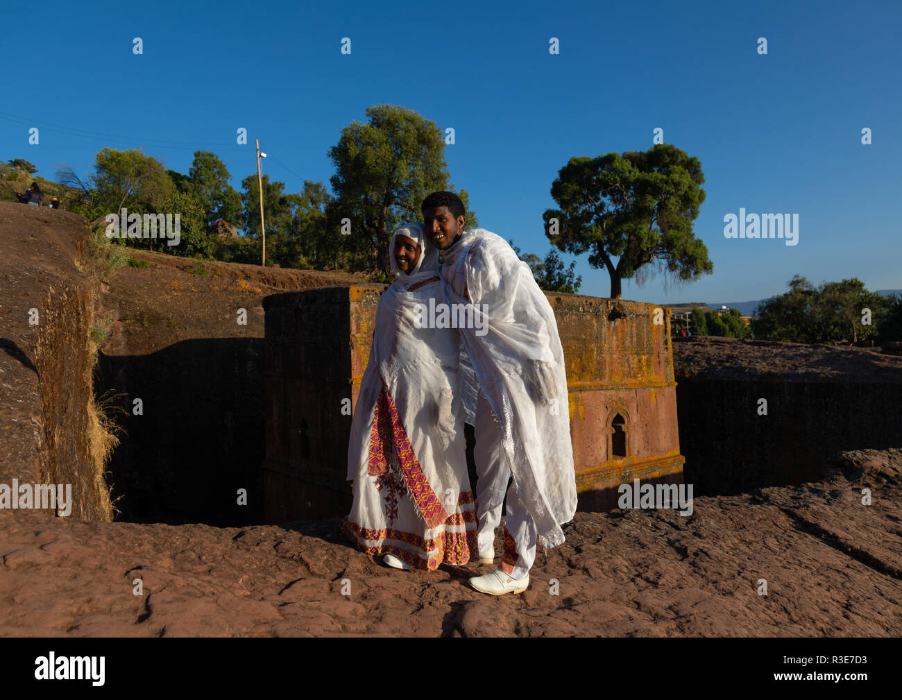 Les nouveaux mariés éthiopien s'arrêtant en face de l'église monolithique rock-cut de bete giyorgis, région d'Amhara, Lalibela, Éthiopie Banque D'Images
