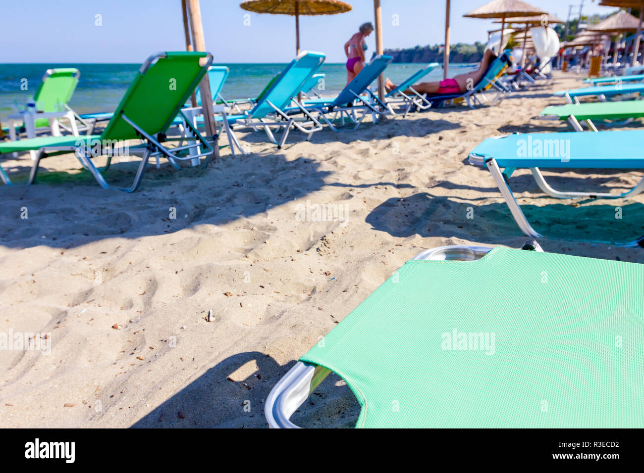 Vue sur la plage publique de vide avec des parasols en chaume, parasols et chaises longues pour des vacances parfaites. Banque D'Images