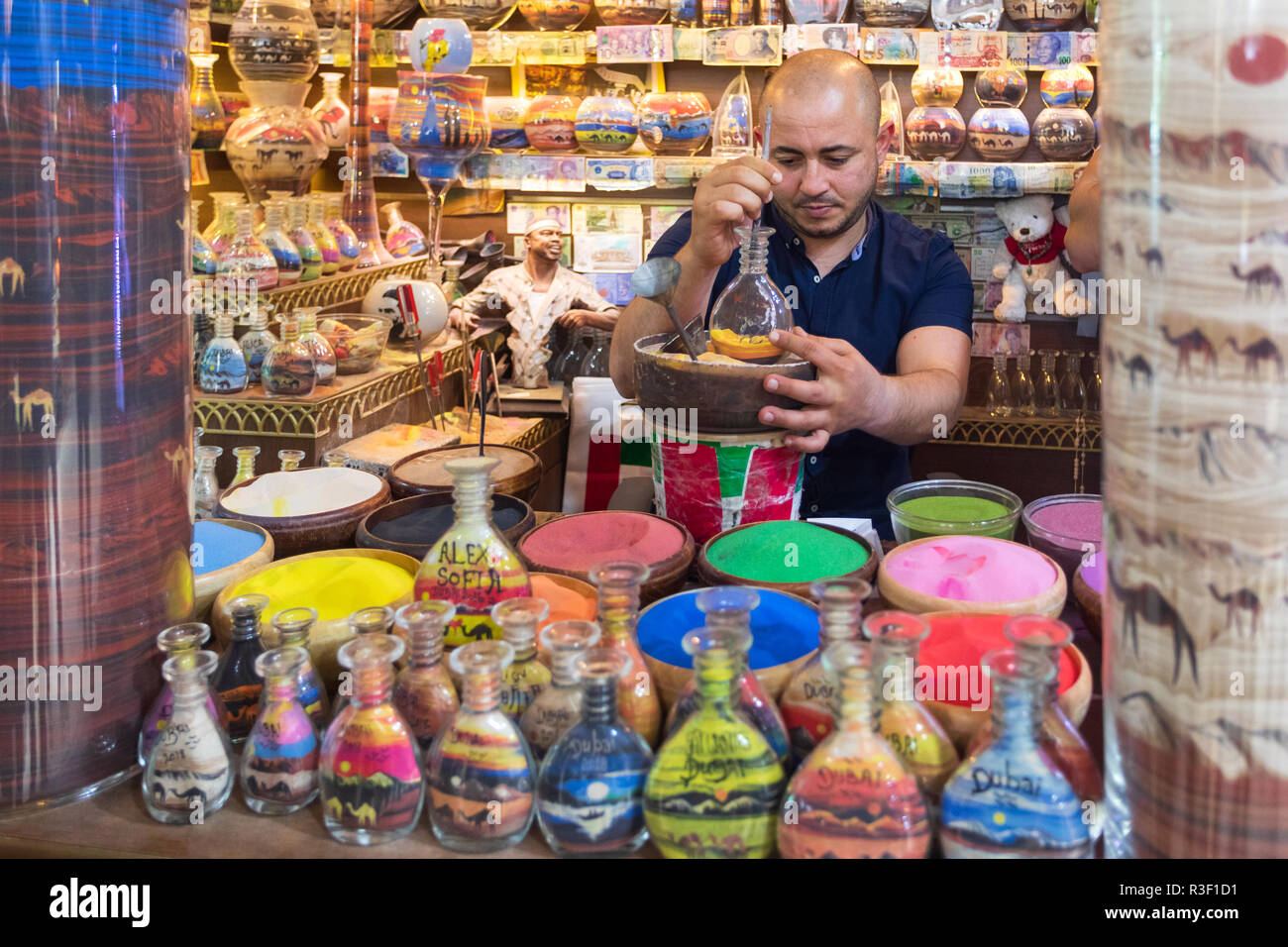 Dubaï, Émirats arabes unis - 12 novembre 2018 : Boutique de souvenirs à l'Atlantis Hôtel avec artisan faisant de souvenirs des bouteilles remplies de sable de couleur en forme de chameau Banque D'Images